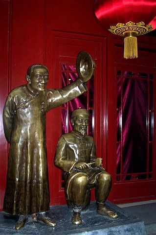 Rue qianmen - Statues d'ouvrier et propriétaire chinois
